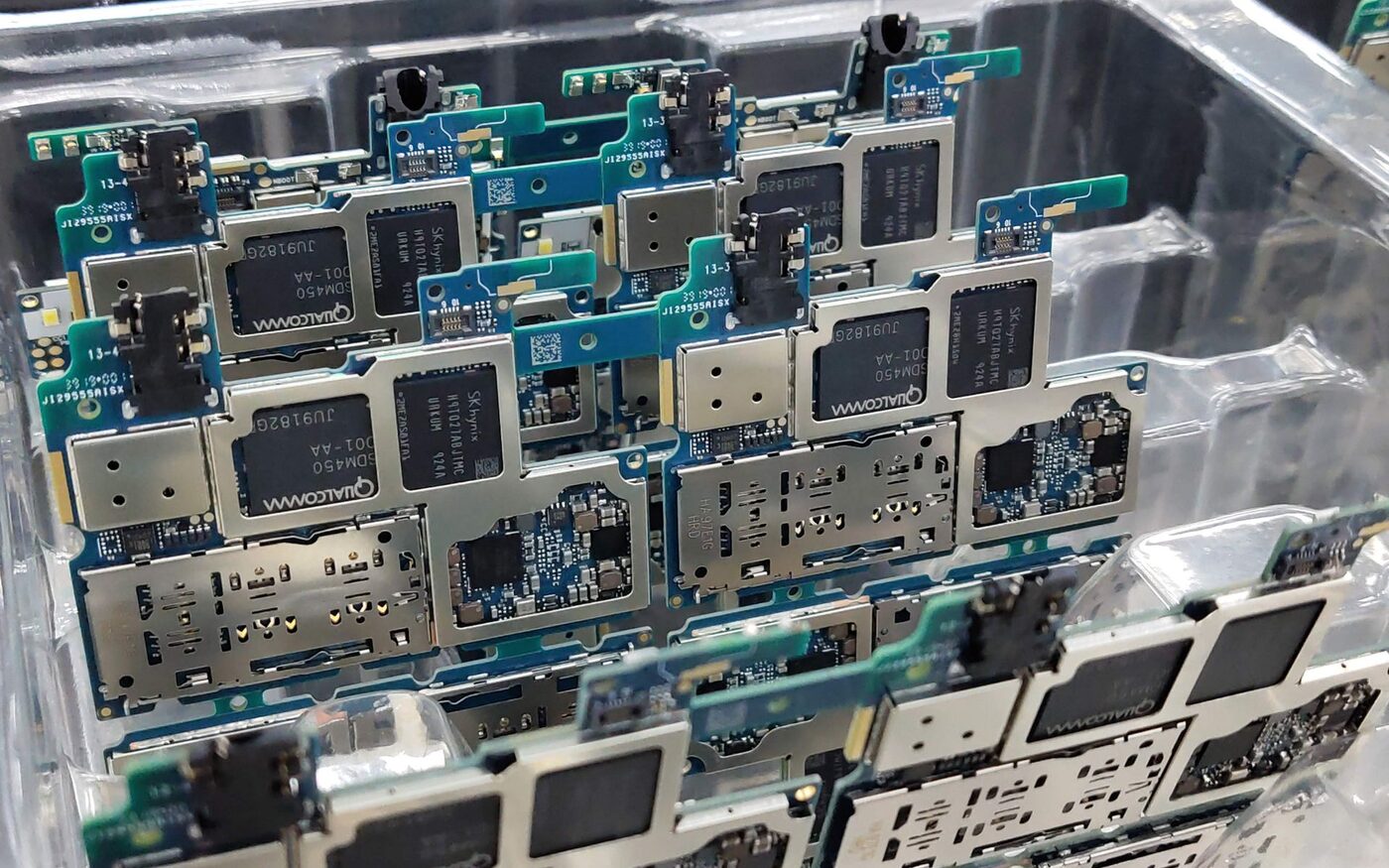 Assembled circuit boards laid out in anti-static trays on a production line.
